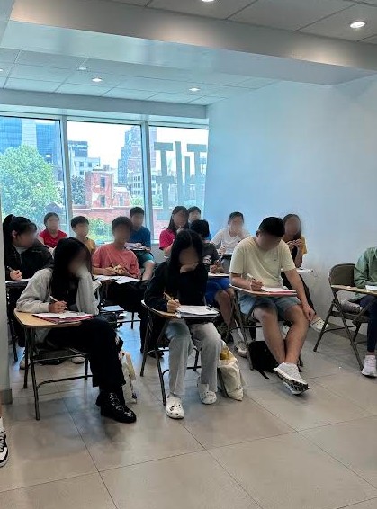Dedicated students working on mock exam questions and classwork in individual desks